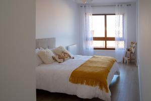 ein Schlafzimmer mit einem Bett mit einer gelben Decke darauf in der Unterkunft O Son in Porto do Son