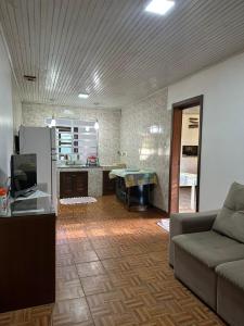 sala de estar con sofá y cocina en Pousada Ananda, en Osório