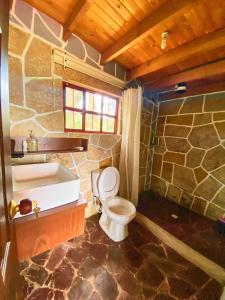 a bathroom with a toilet and a sink and a tub at CASA DE PIEDRA EL ZAPATO in Suesca