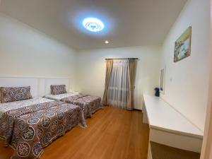 een slaapkamer met 2 bedden en een witte muur bij Bukit Gambang Waterpark Villa in Kuantan
