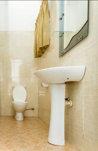 ein Badezimmer mit einem weißen Waschbecken und einem WC in der Unterkunft Lovely 2-bedroom house near Aburi in Accra