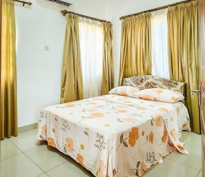 ein Schlafzimmer mit einem Bett mit einer Decke darauf in der Unterkunft Lovely 2-bedroom house near Aburi in Accra