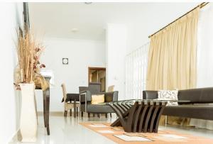 ein Wohnzimmer mit Stühlen und einem Tisch in der Unterkunft Lovely 2-bedroom house near Aburi in Accra