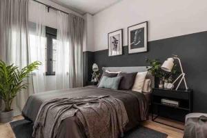 1 dormitorio con cama y pared negra en Precioso estudio compartido a 10 minutos del aeropuerto, en Madrid