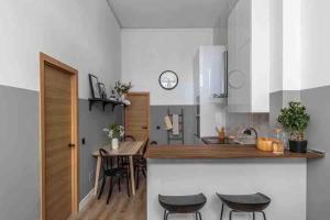 una cocina con mesa y sillas y un reloj en la pared en Precioso estudio compartido a 10 minutos del aeropuerto, en Madrid