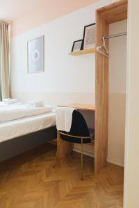 1 dormitorio con cama, escritorio y silla en Malfatti Room Oasis with coworking space, en Viena
