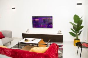 a living room with a red couch and a tv at Luxueux Appartement meublé à Cotonou in Cotonou