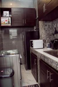 科托努的住宿－Luxueux Appartement meublé à Cotonou，厨房配有水槽和微波炉