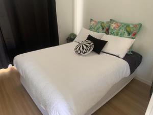 un letto con lenzuola e cuscini bianchi in una camera da letto di Yandina Caravan Park a Yandina