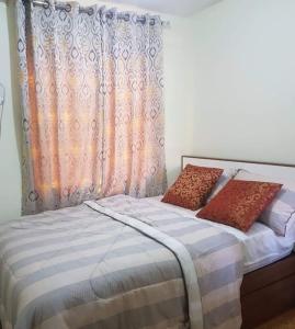 a bedroom with a bed with two pillows on it at SAN REMO OASIS 2BR COMFORT 30sqm in Cebu City
