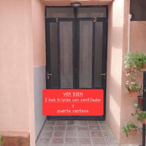 una puerta negra con una señal roja delante de ella en EL ZAGUAN ANEXO I en Cafayate