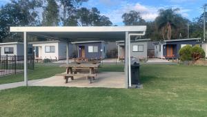a picnic shelter with a picnic table in a park at Yandina Caravan Park in Yandina