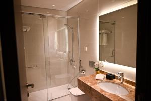 a bathroom with a glass shower and a sink at فندق سافوي جدة Savoye Hotel in Jeddah