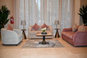 uma sala de estar com dois sofás e uma mesa de centro em فندق سافوي جدة Savoye Hotel em Jeddah