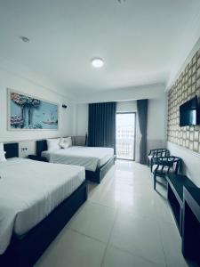 um quarto de hotel com duas camas e uma televisão em Levan Hotel em Phu Quoc