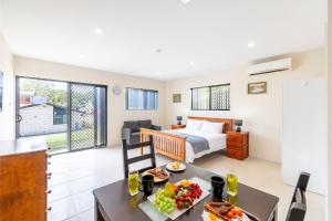 a room with a bed and a table with food on it at 14A Grafton St - Pet friendly air con studio for a couples retreat in Nelson Bay