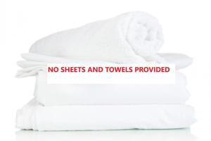 uma pilha de toalhas com uma placa que diz que não são fornecidos lençóis e toalhas em 14A Grafton St - Pet friendly air con studio for a couples retreat em Nelson Bay