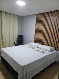 a bedroom with a large bed with two pillows at Casa Angra vista pro mar in Angra dos Reis