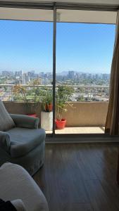 a living room with a couch and a large window at Departamento Vista hermosa in Santiago