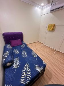 a bedroom with a bed with a blue comforter at Kak Ani Homestay in Pasir Gudang