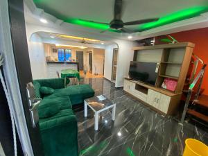 Kak Ani Homestay في باسير غونداغ: غرفة معيشة مع أريكة وتلفزيون بشاشة مسطحة