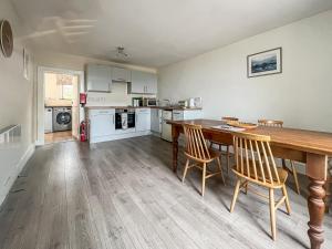 uma cozinha e sala de jantar com uma mesa de madeira e cadeiras em Tigh Na Mara em Helmsdale
