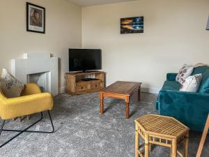uma sala de estar com dois sofás e uma televisão em Tigh Na Mara em Helmsdale