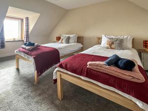 um quarto com 2 camas e toalhas em Tigh Na Mara em Helmsdale