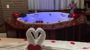 a bath tub with hearts on top of a bed at Pousada Vista Bonita in Visconde De Maua