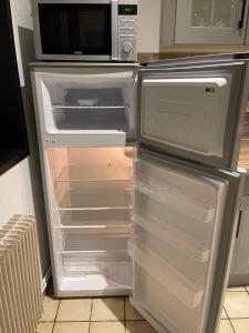 - un réfrigérateur vide avec une porte ouverte dans la cuisine dans l'établissement 09 CHIC & COSY GRAND APPART 4 PIÈCES 75m2 HYPERCENTRE WIFI SMART TV NETFLIX, à Saint-Étienne