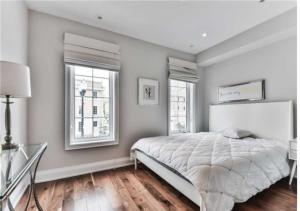 a bedroom with a large bed and two windows at Immaculate Executive Townhouse 3Br&3Ba at Lawrence Park in Toronto