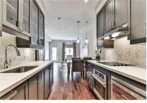 una grande cucina con pavimenti in legno ed elettrodomestici in acciaio inossidabile di Immaculate Executive Townhouse 3Br&3Ba at Lawrence Park a Toronto
