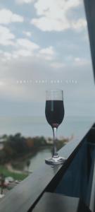 a glass of wine sitting on top of a balcony at Apart Otel Orbi City in Batumi
