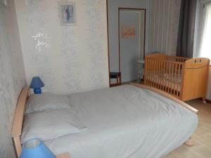 łóżko w pokoju z łóżeczkiem dziecięcym w pokoju w obiekcie Gîte Cornimont, 3 pièces, 5 personnes - FR-1-589-70 w mieście Cornimont