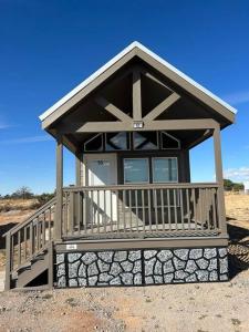 a small building with a porch on a beach at 93 Star Gazing Tiny Home Sleeps 8 in Valle