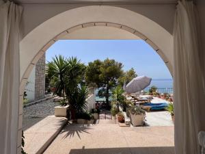 un arco che conduce a un resort con piscina di Apartments by the sea Tucepi, Makarska - 21719 a Tučepi