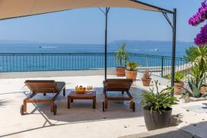 un patio con un tavolo, due sedie e un ombrellone di Apartments by the sea Tucepi, Makarska - 21719 a Tučepi Altre 8 foto
