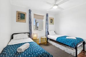 a bedroom with two beds and a mirror at Esplanade Absolute Beach Frontage 12-20 in Torquay