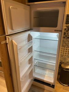 um frigorífico vazio com a porta aberta numa cozinha em 010 CHIC & COSY F1 29m2 HYPERCENTRE WIFI SMART TV NETFLIX em Saint-Étienne