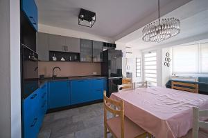 cocina y comedor con armarios azules y mesa en Apartments by the sea Postira, Brac - 22030, en Postira