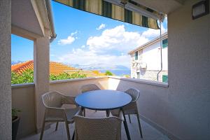 Una mesa y sillas en un balcón con vista. en Apartments by the sea Postira, Brac - 22030, en Postira