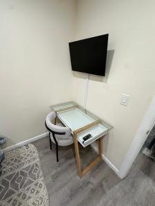 szklany stół z krzesłem i telewizor na ścianie w obiekcie LUXE Private & Modern Close to New York City w mieście New Rochelle