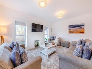uma sala de estar com dois sofás e uma mesa em Whinstone House em Craster