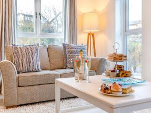 ein Wohnzimmer mit Sofa und Tisch mit Essen drauf in der Unterkunft Whinstone House in Craster