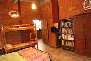 Habitación con 2 literas y estante para libros. en Teak house, en Timuran