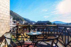 a table and chairs on a balcony with a view at Lake & The City in Como