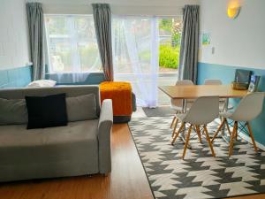 a living room with a couch and a table at Aarangi Tui Motel in Paihia