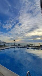 a large swimming pool with a view of the ocean at Apartamento Luxury frente al mar in Cartagena de Indias