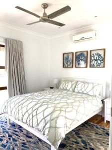 1 dormitorio con 1 cama y ventilador de techo en Hannah's Place in the heart of Lovedale, Hunter Valley wine country, Free bottle of wine with each booking, en Lovedale