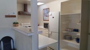 a white kitchen with a refrigerator and a microwave at Ruapehu Mountain Motel & Lodge in Ohakune